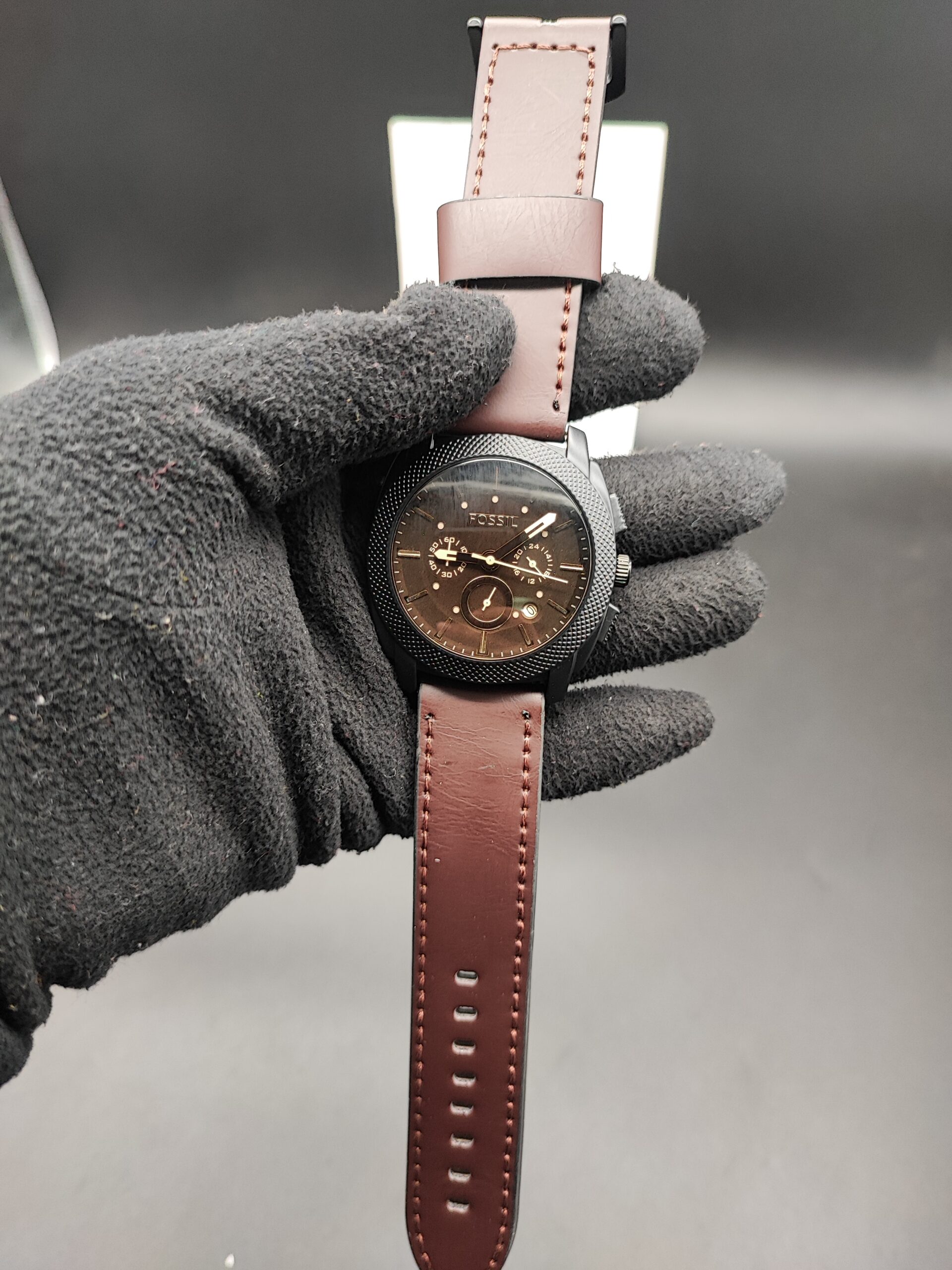 Fossil men's watch with brown dial, black case, multi-function display, and brown leather strap