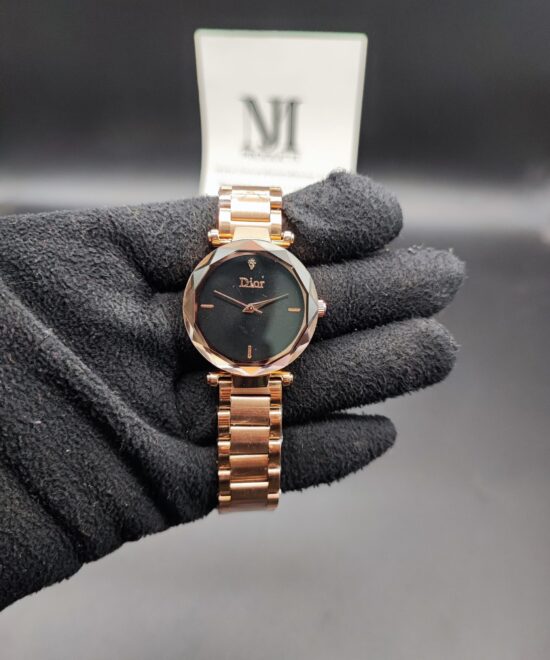 Dior style women's luxury watch featuring a faceted diamond-cut rose gold bezel, a shimmering black starry night sky dial, and a polished black link bracelet held in a black gloved hand.