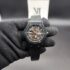 Hublot style Classic Fusion men's skeleton automatic watch featuring a matte black bezel with exposed silver screws, a fully open-worked mechanical skeleton dial with silver gears and a red seconds hand, attached to a black rubber strap held in a black gloved hand.